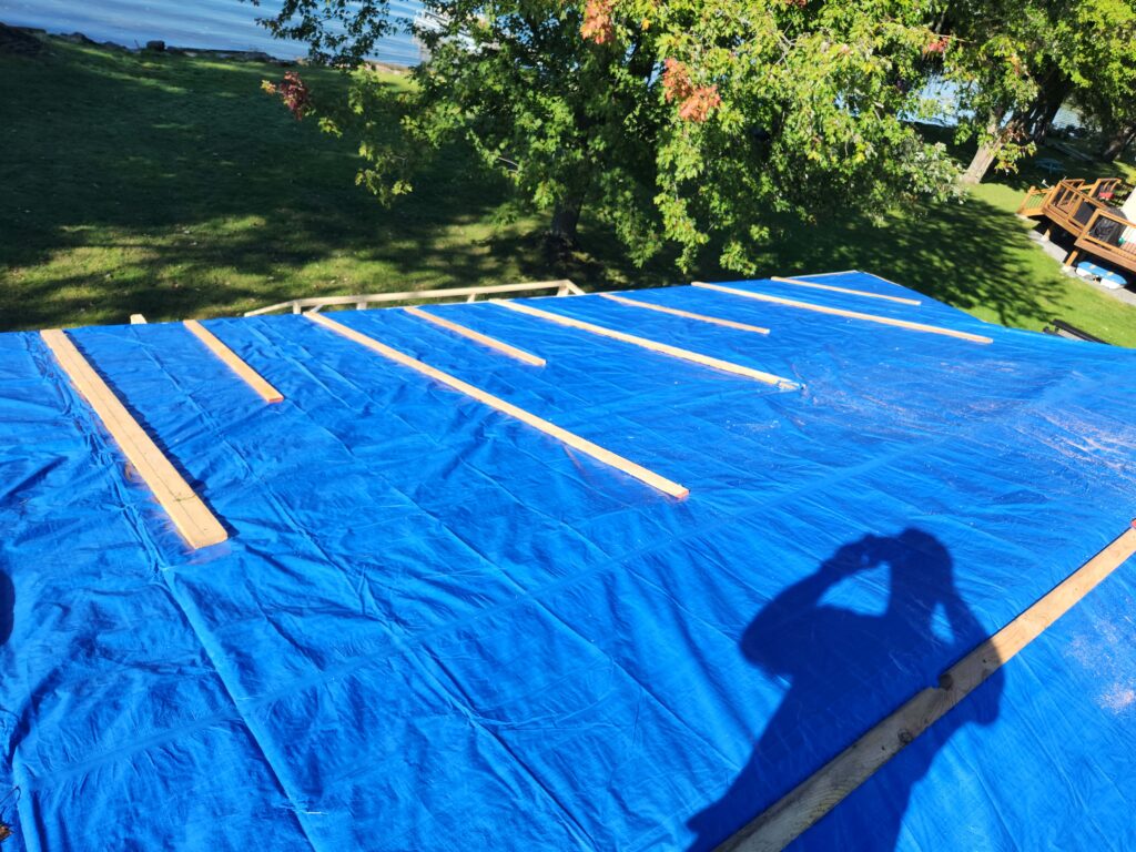 Cottage roof fully tarped and strapped for wind protection – Trenton