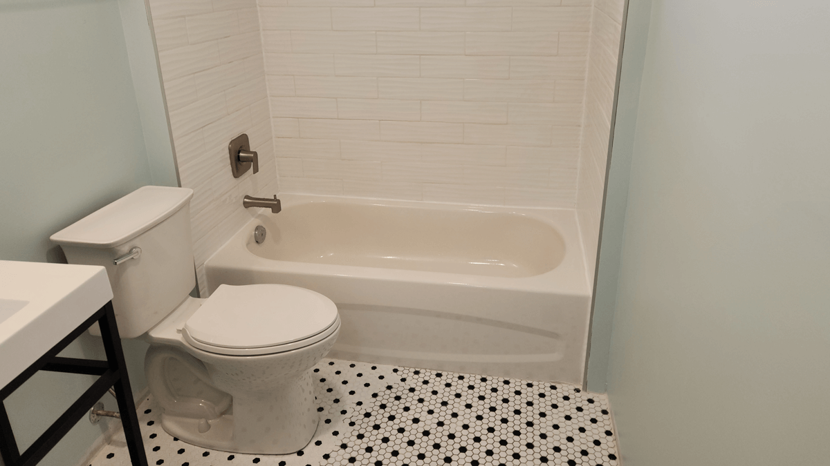 Newly renovated bathroom. Small tiles on floor, tub install, vanity