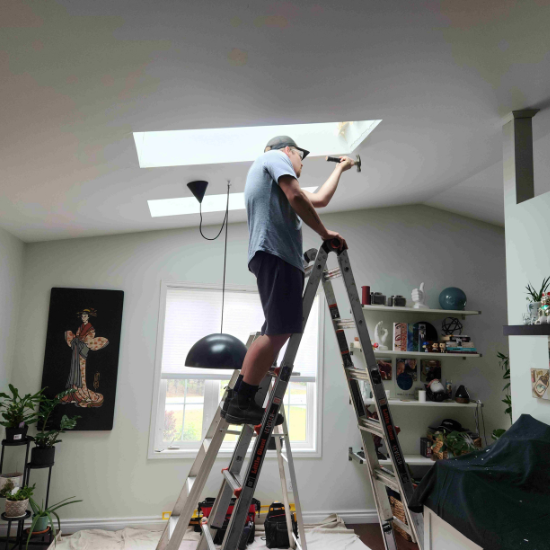 Man on ladder finishing ceiling