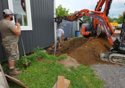 Mini excavator outside a home with drill attachment