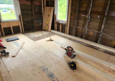 Torn out walls and plywood flooring installed in part of home renovation