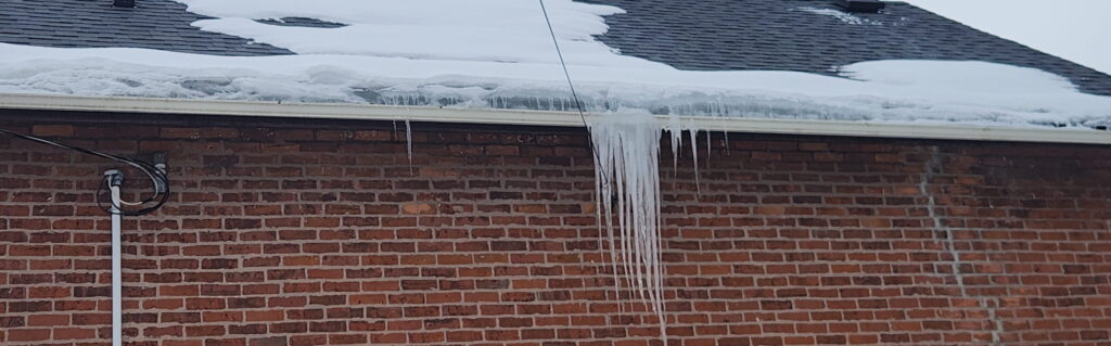 Long icicles hanging from gutters due to ice dam formation